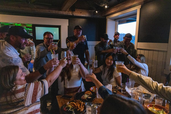 Friends toasting drinks at restaurant table indoors