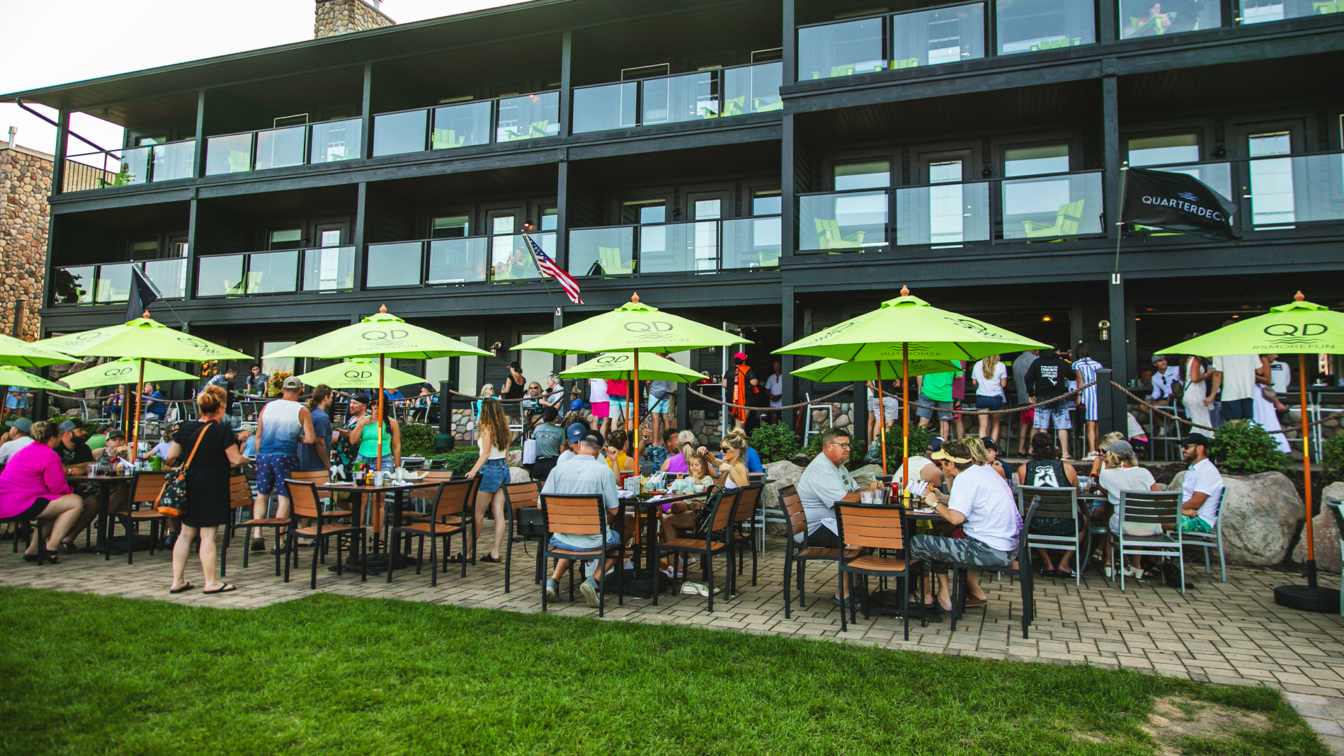 Crowded outdoor restaurant patio with green umbrellas
