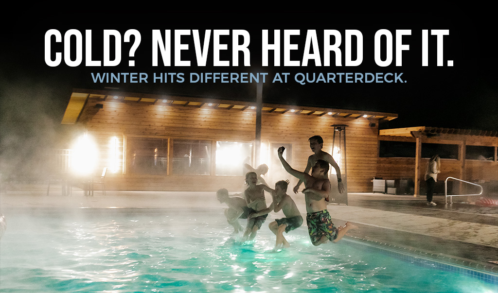 Friends jumping into a steaming outdoor pool at night